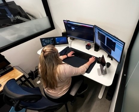 A remote-support monitor is sitting in front of her office computer.