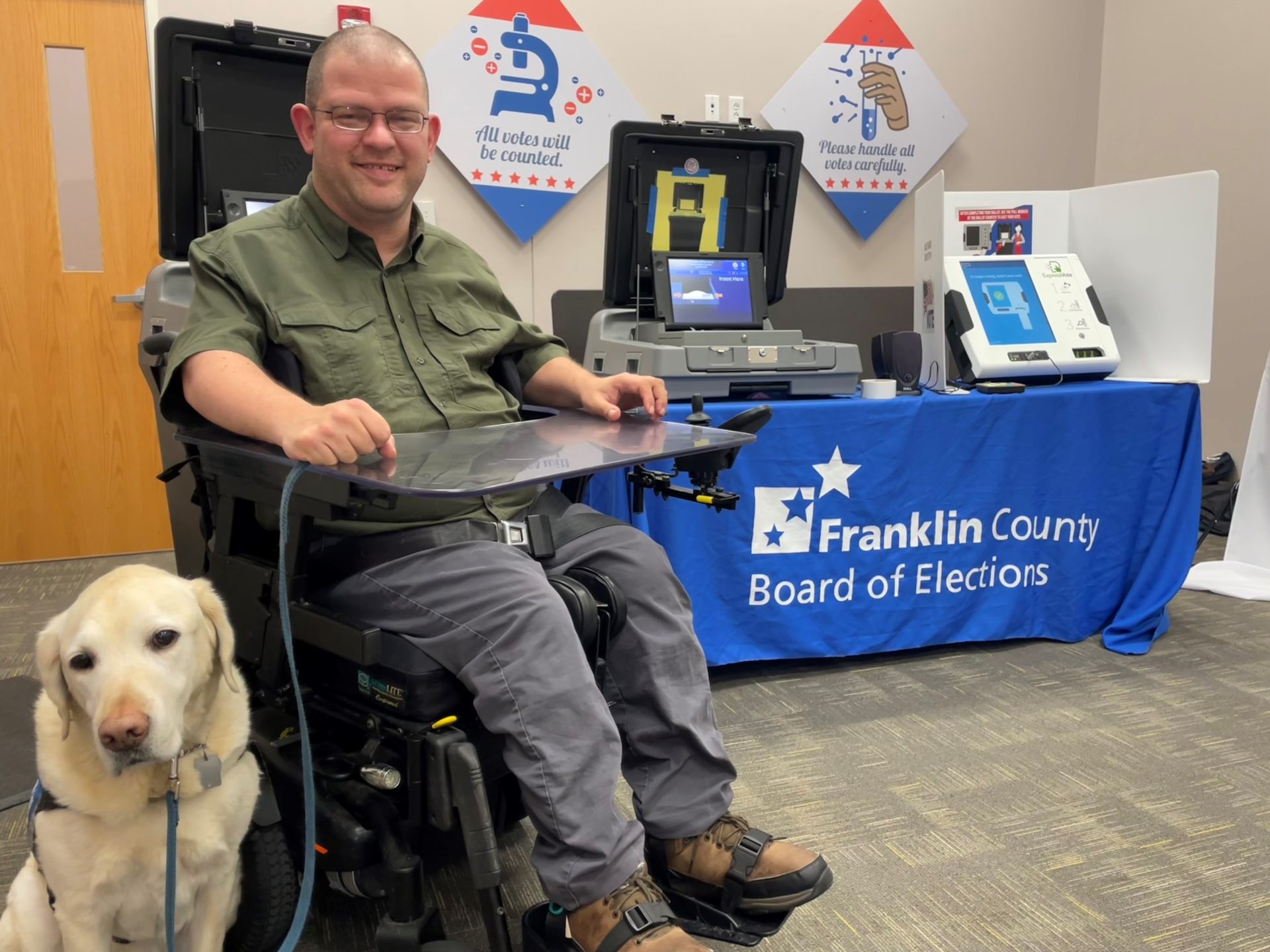 Man in wheelchair with service dog at Board of Elections