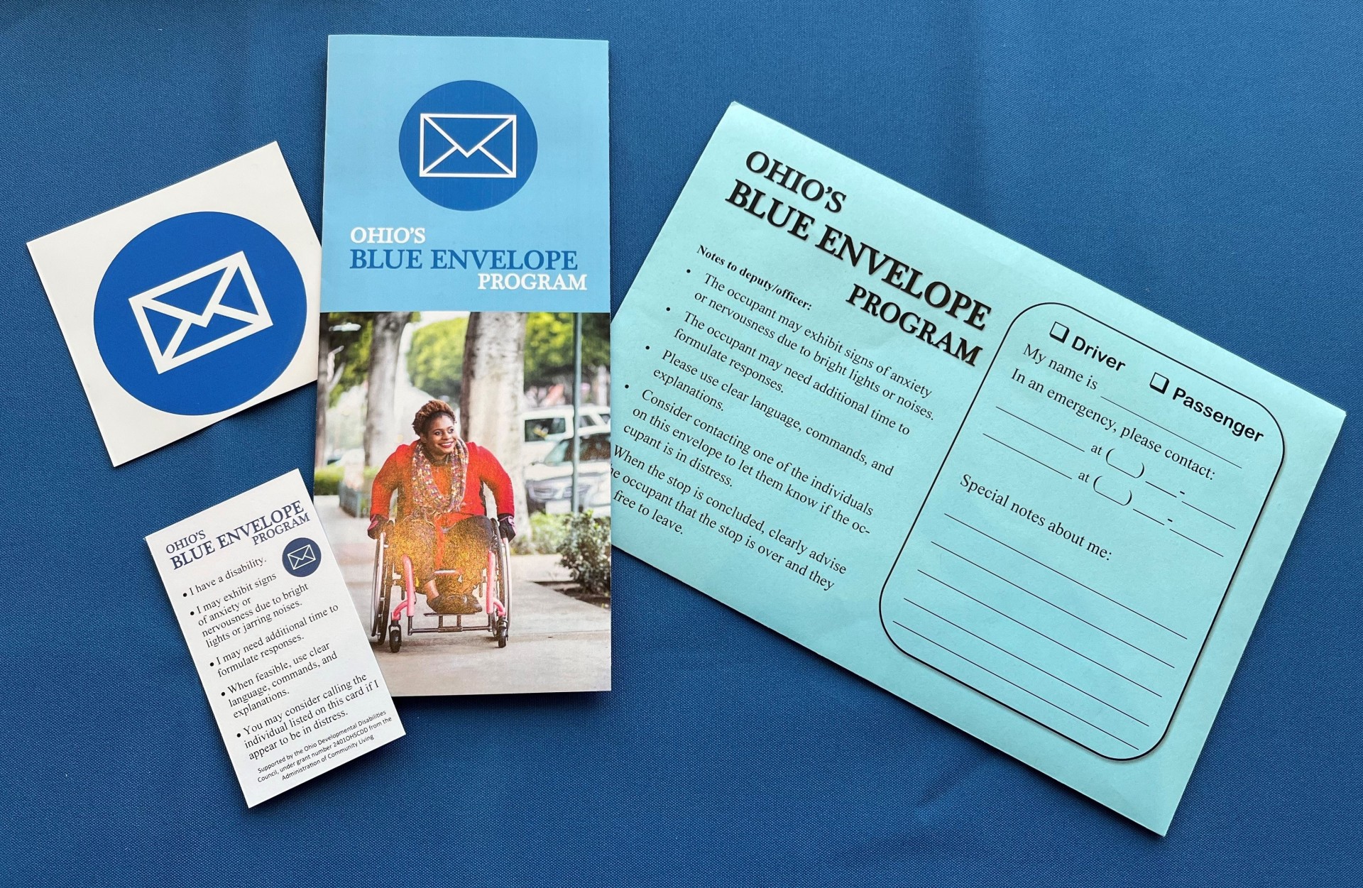 Photo of Blue Envelope, brochure, car decal and wallet card