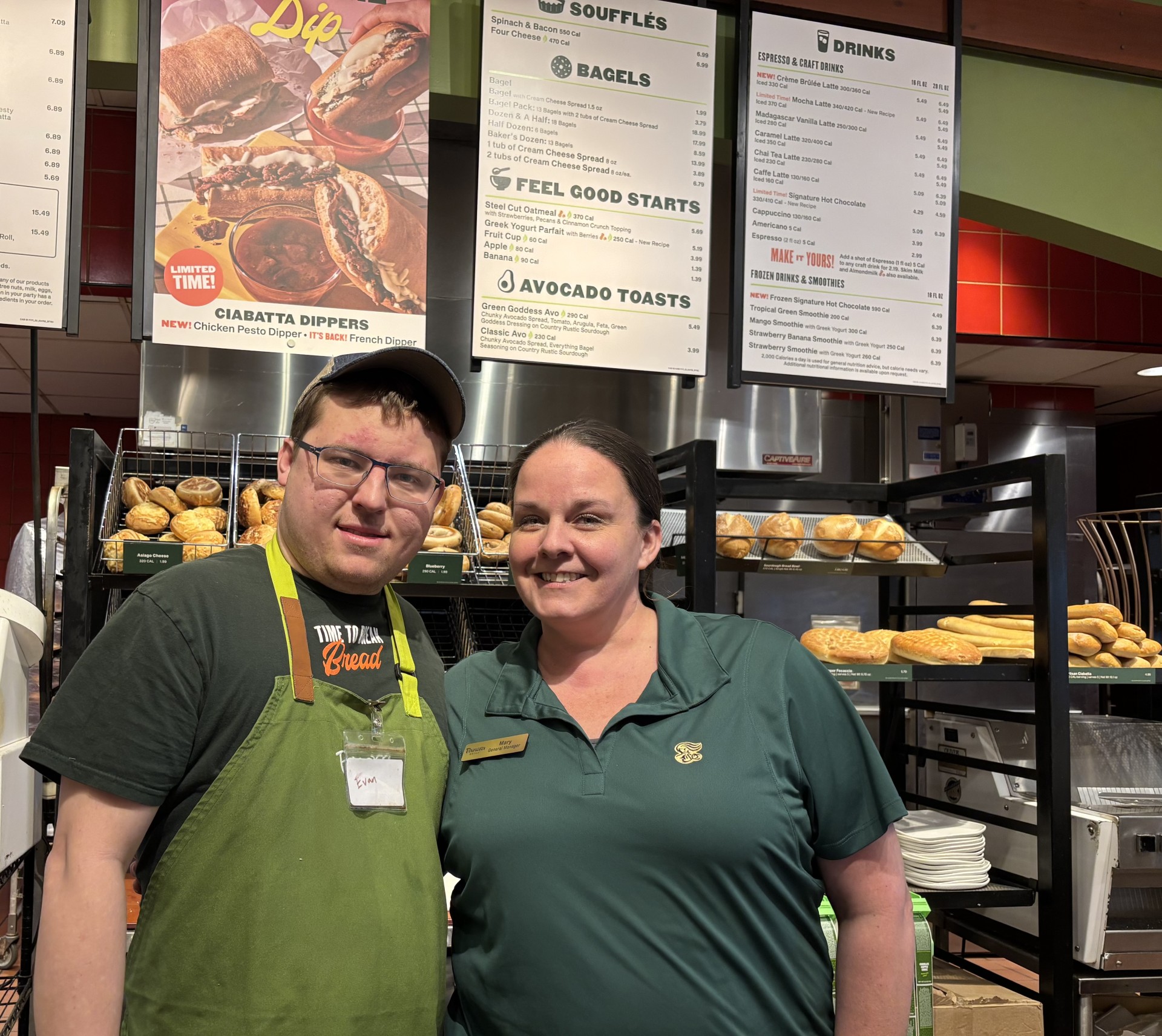 Panera employee wearing apron and smiling next to his supervisor